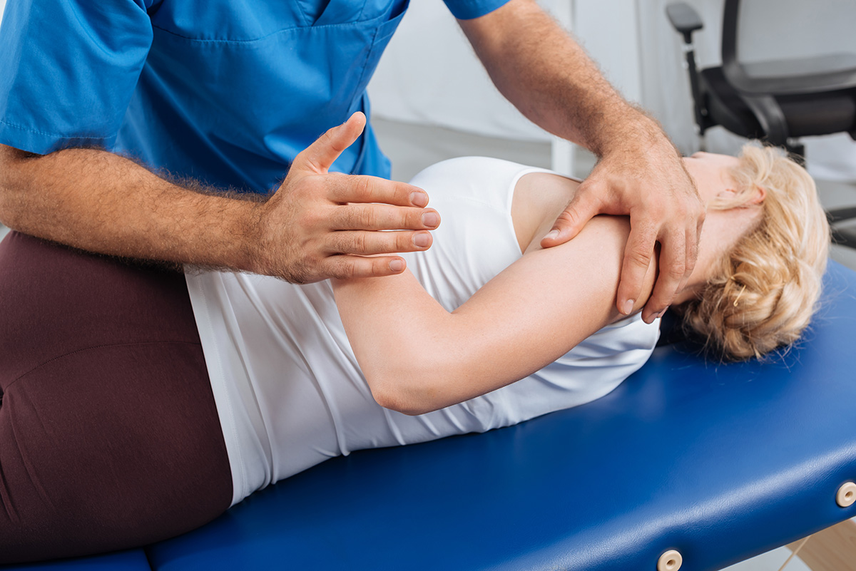 cropped shot of physiotherapist stretching patient on massage ta cropped shot of physiotherapist stretching patient on massage